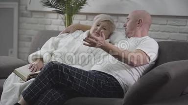 英俊的白种人老男人抱着妻子说话。 成熟的男人在感情上做<strong>手势</strong>。 一对恋爱中的<strong>情侣</strong>